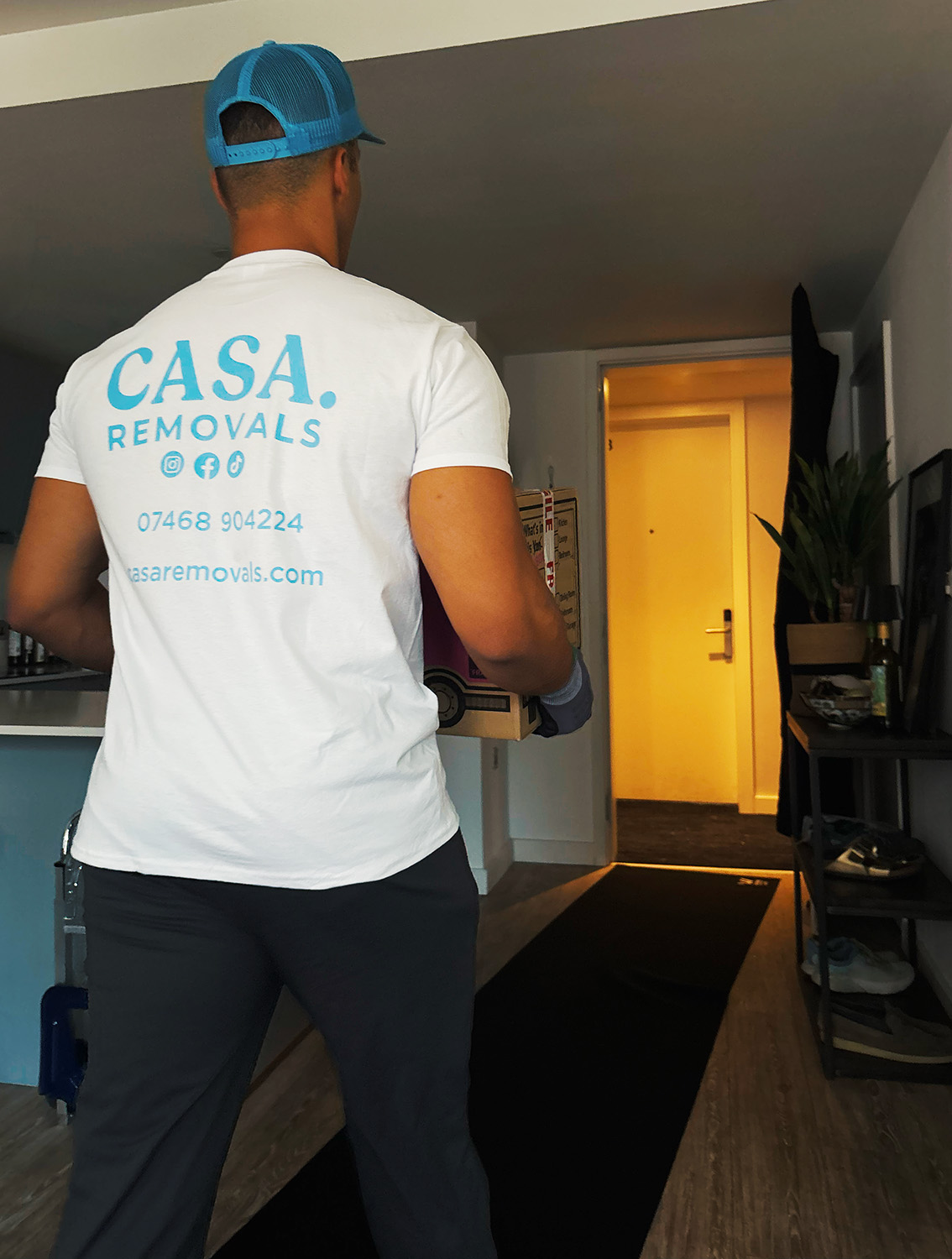 A CASA. crew member carrying a box into a London home