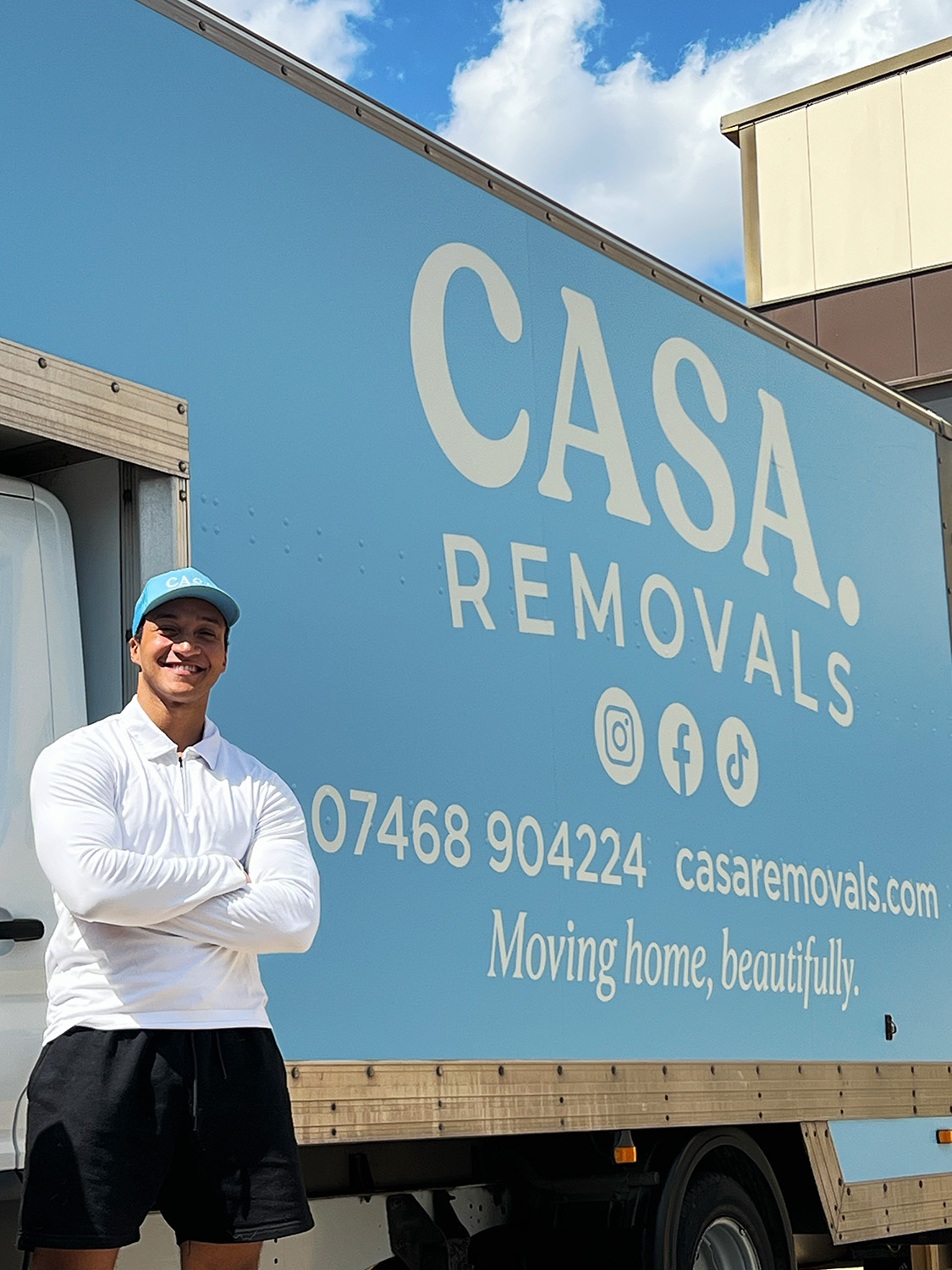 A smiling CASA. crew member in front of the blue van